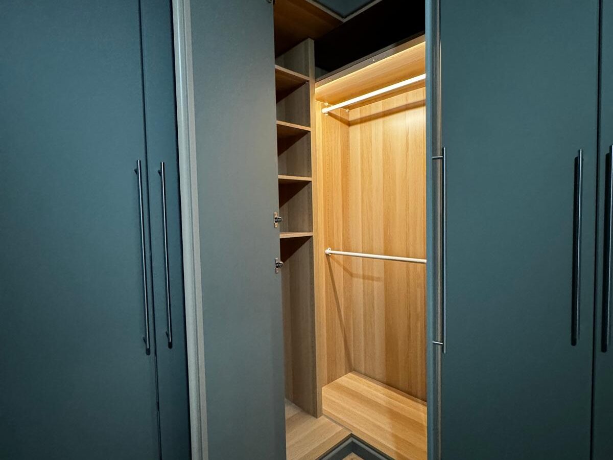 Dressing bleu pétrole, intérieur bois, réalisation Mobel Design à Genève