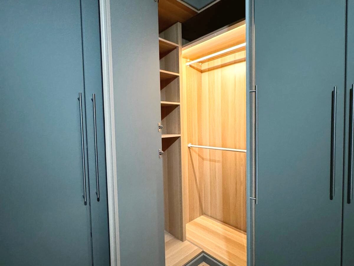 Dressing bleu pétrole, intérieur bois, réalisation Mobel Design à Genève
