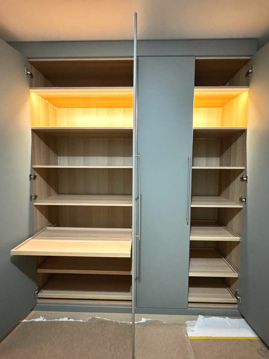 Petrol-blue wardrobe with lit shelves